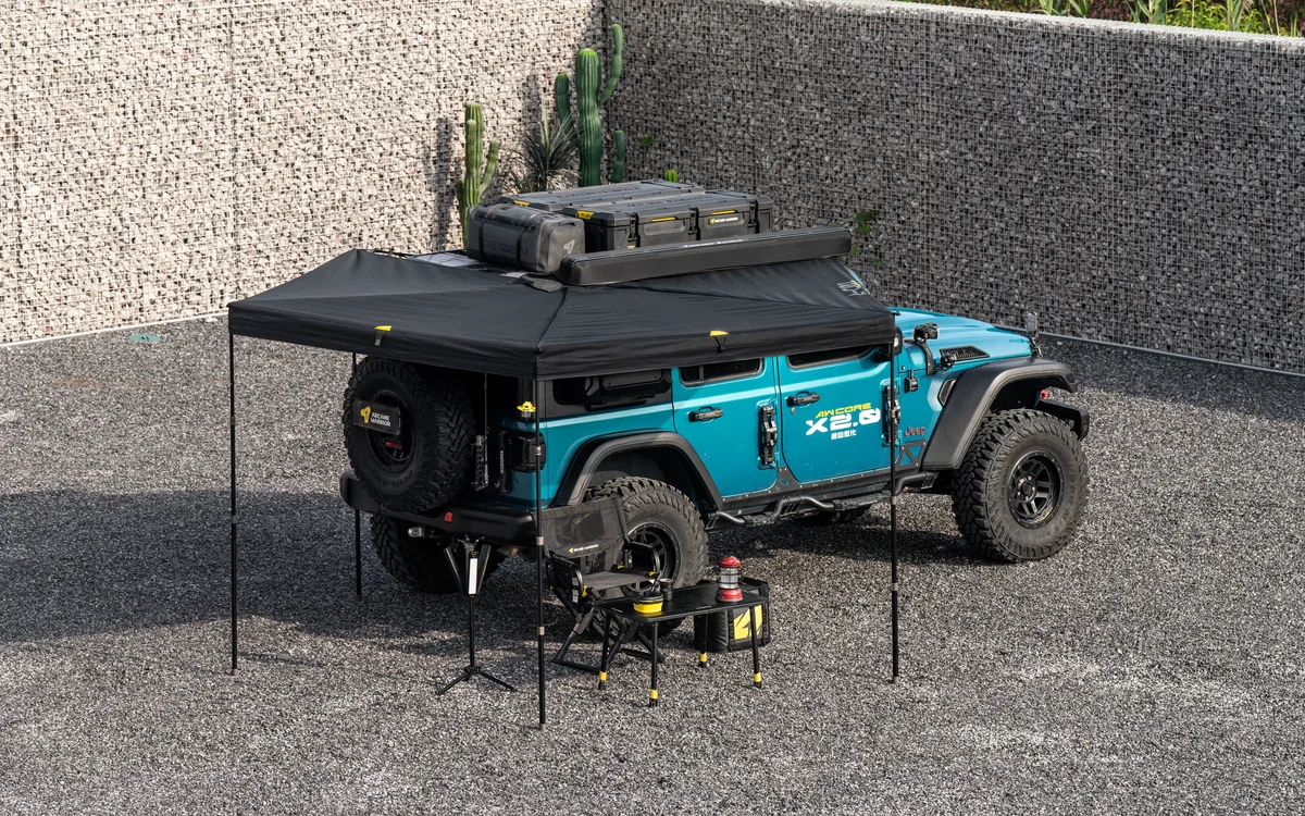 LITEWING awning deployed around the side and rear of a blue off-road vehicle