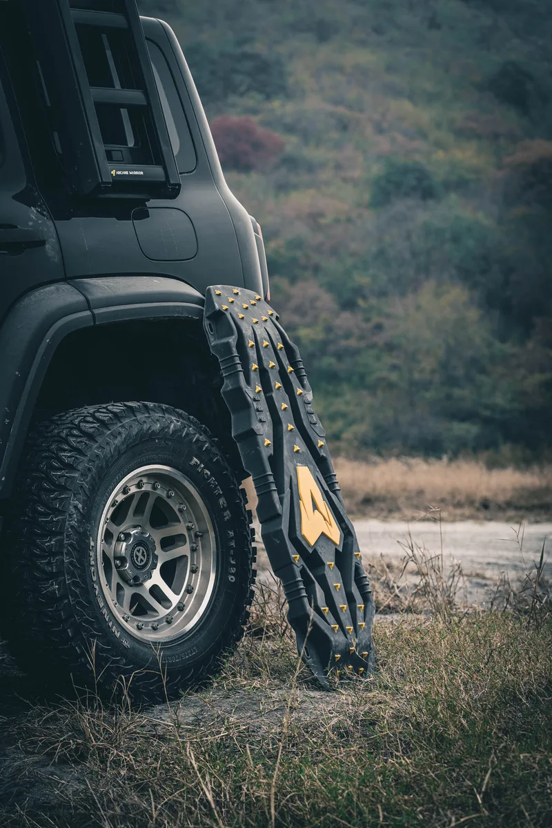 Arcane Warrior ATR recovery boards beside an off-road vehicle