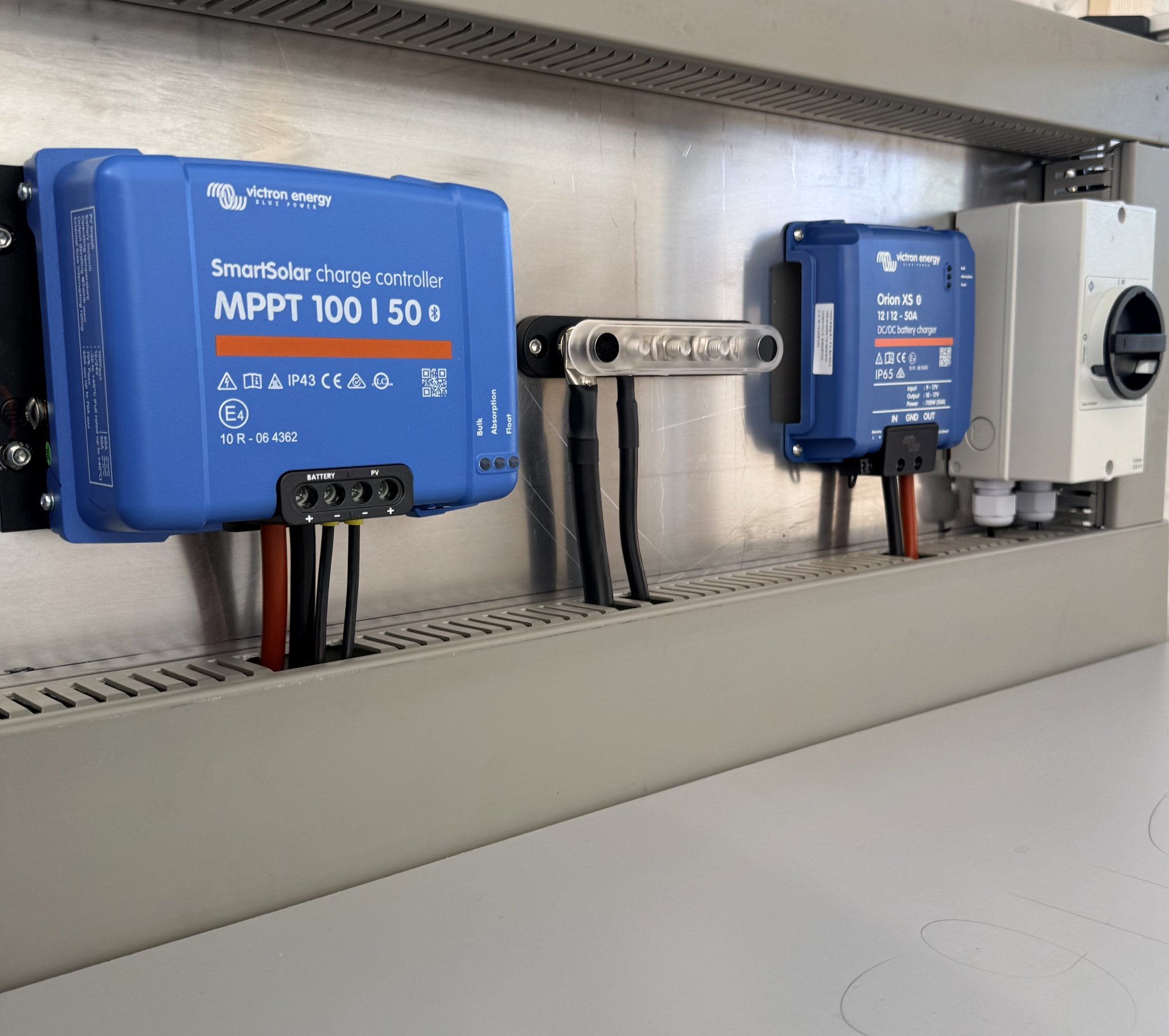 Victron SmartSolar MPPT and Orion XS chargers bolted to an aluminium plate in the Wildbox workshop.